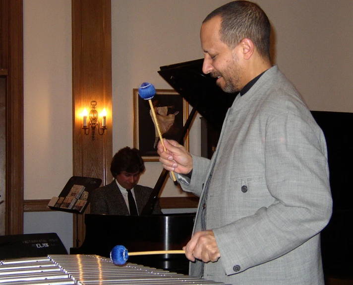 a man in grey suit playing a small instrument