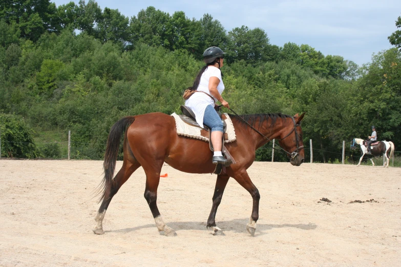 a lady in white is riding her horse