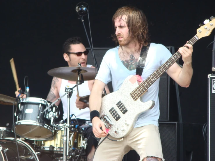 the young man in glasses is playing his guitar