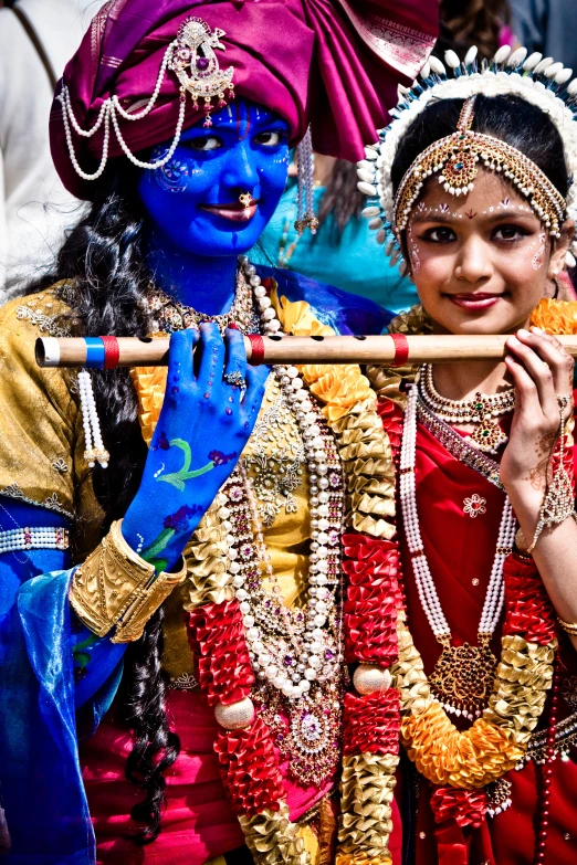 two people with paint smeared on their face with sticks