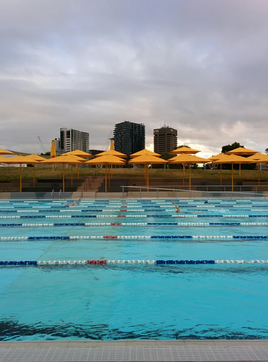 a very large pool with several swimming areas and umbrellas