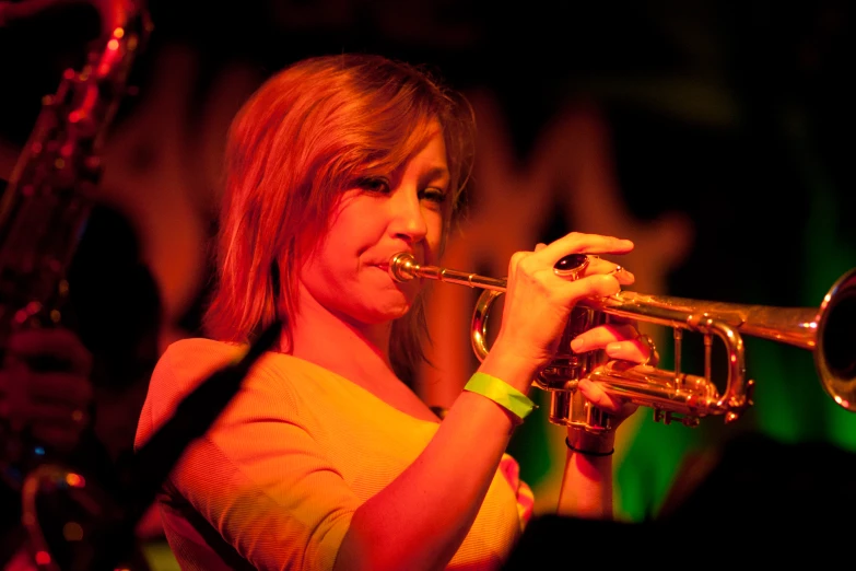 a female holding a trumpet while playing it