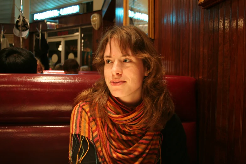 woman in cafe sitting down on red leather chair