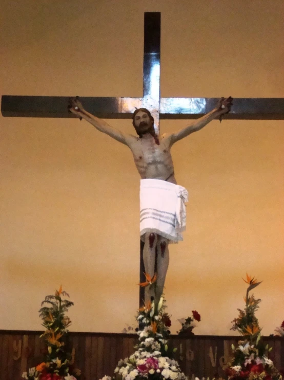 a large cross with flowers in a room