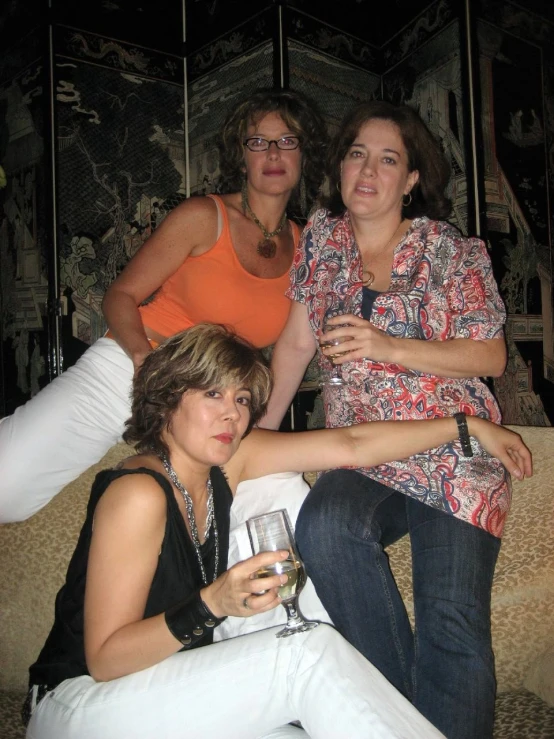 a group of three ladies sitting on a couch