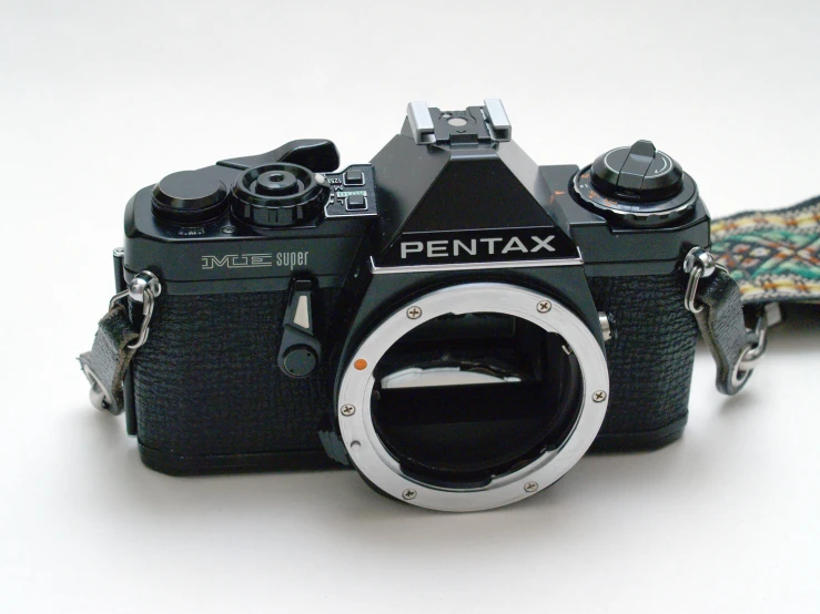 a pentax camera with its lens on a leash