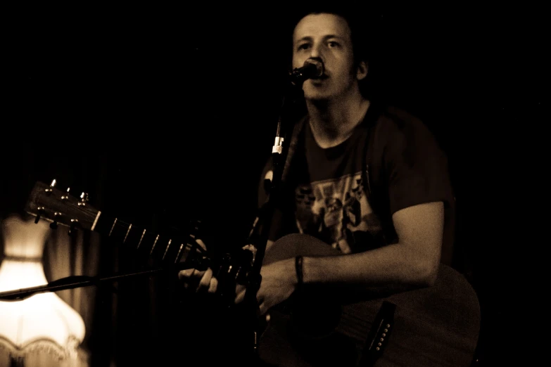 a man holding an acoustic guitar with his hands