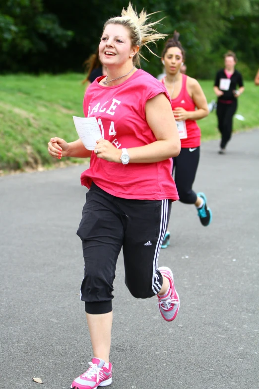 women running together with one holding a book