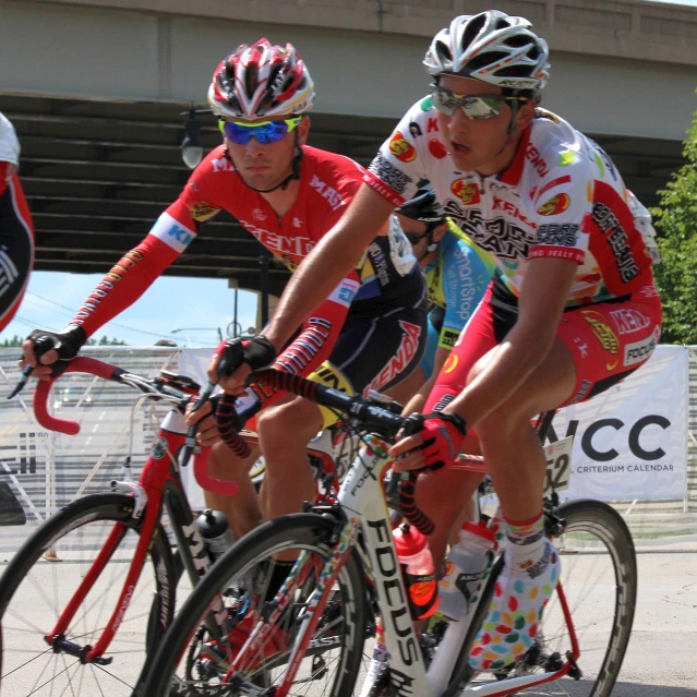 there are men on bikes racing down a street