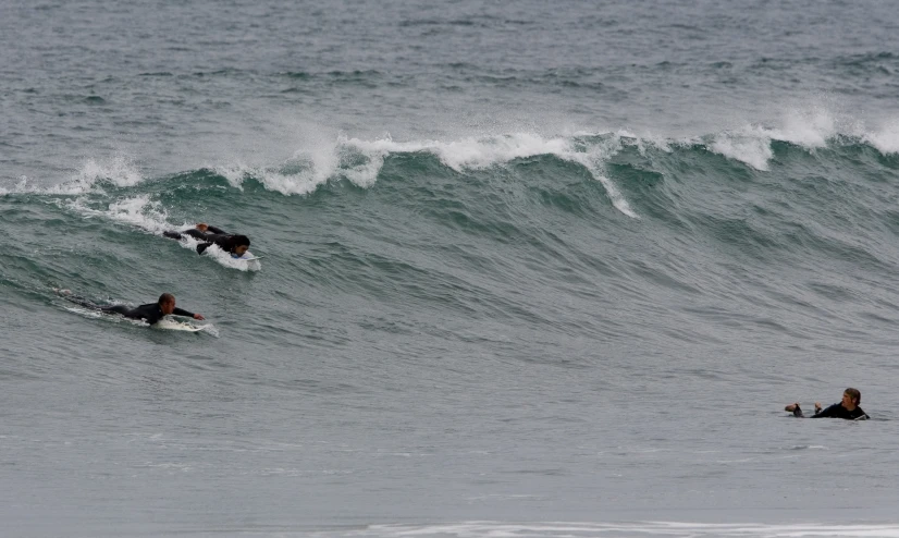 a group of people surfing a wave in the ocean