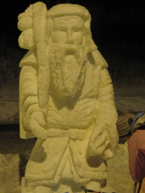 a statue made with sand and candles next to a chair