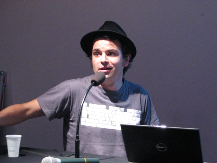 a young man talking into a microphone and speaking into a microphone