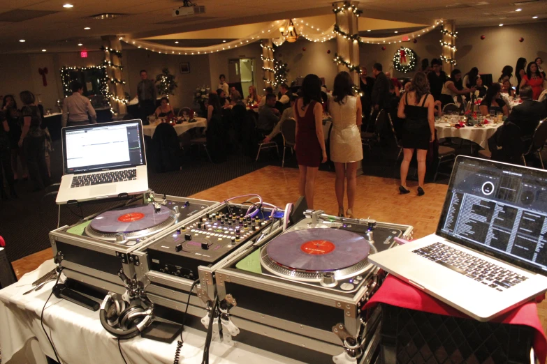 a dj's turntables are on a wooden floor in front of an audience