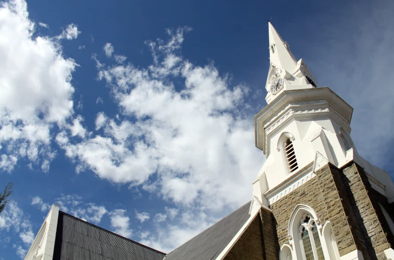 a church steeple and clock against a blue sky