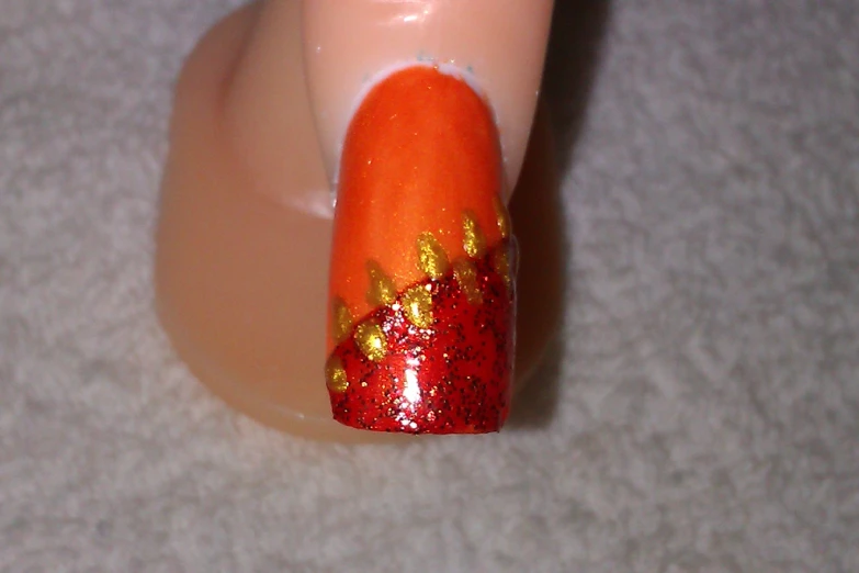 there is a orange nail with golden stars on it