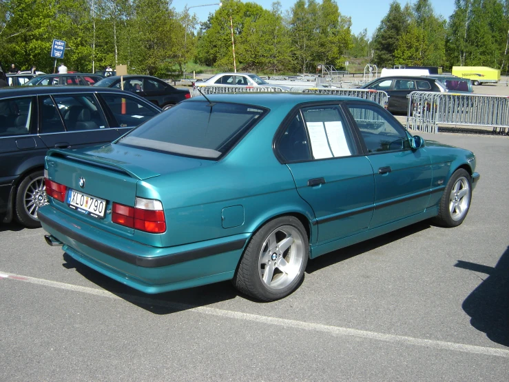 blue car parked in parking lot with other cars