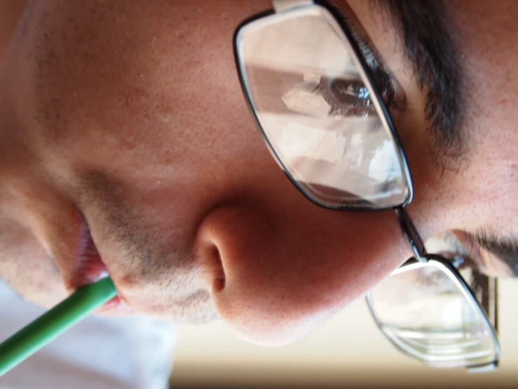 a man taking a bite out of a green drink