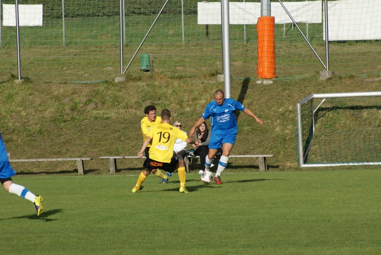 soccer players running toward the ball during a game