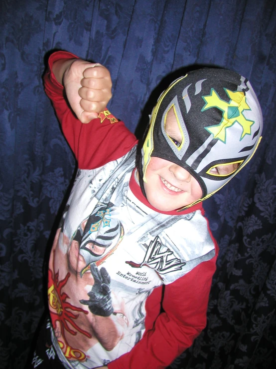 a  wearing a wrestling costume holding his fist up in the air