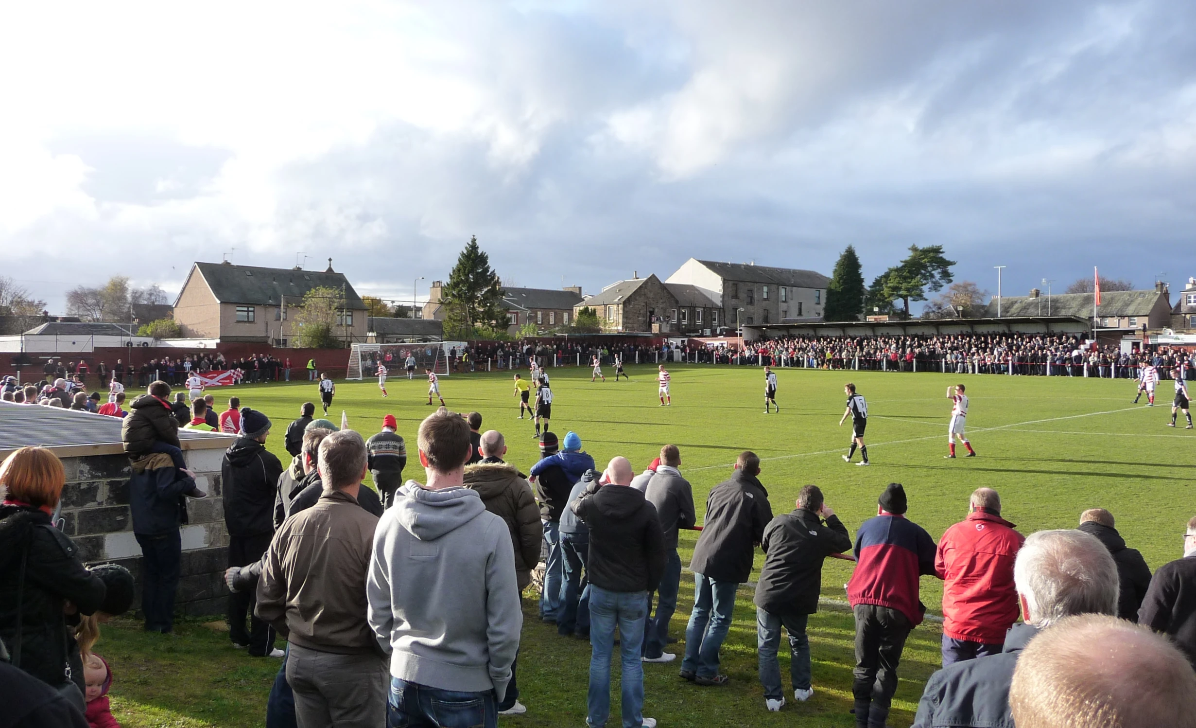 a group of people on a field with some playing soccer