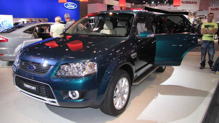 people stand in front of an suv at a showroom