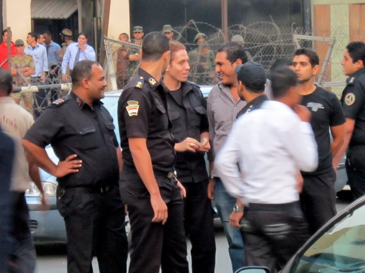 group of men in police uniform standing in front of a car