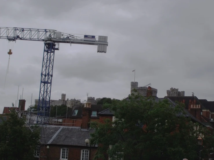 a crane is near buildings that have a clock on it