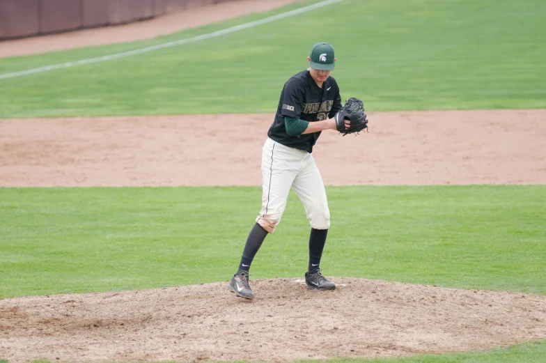 a man is standing on the pitchers mound in his uniform and playing baseball