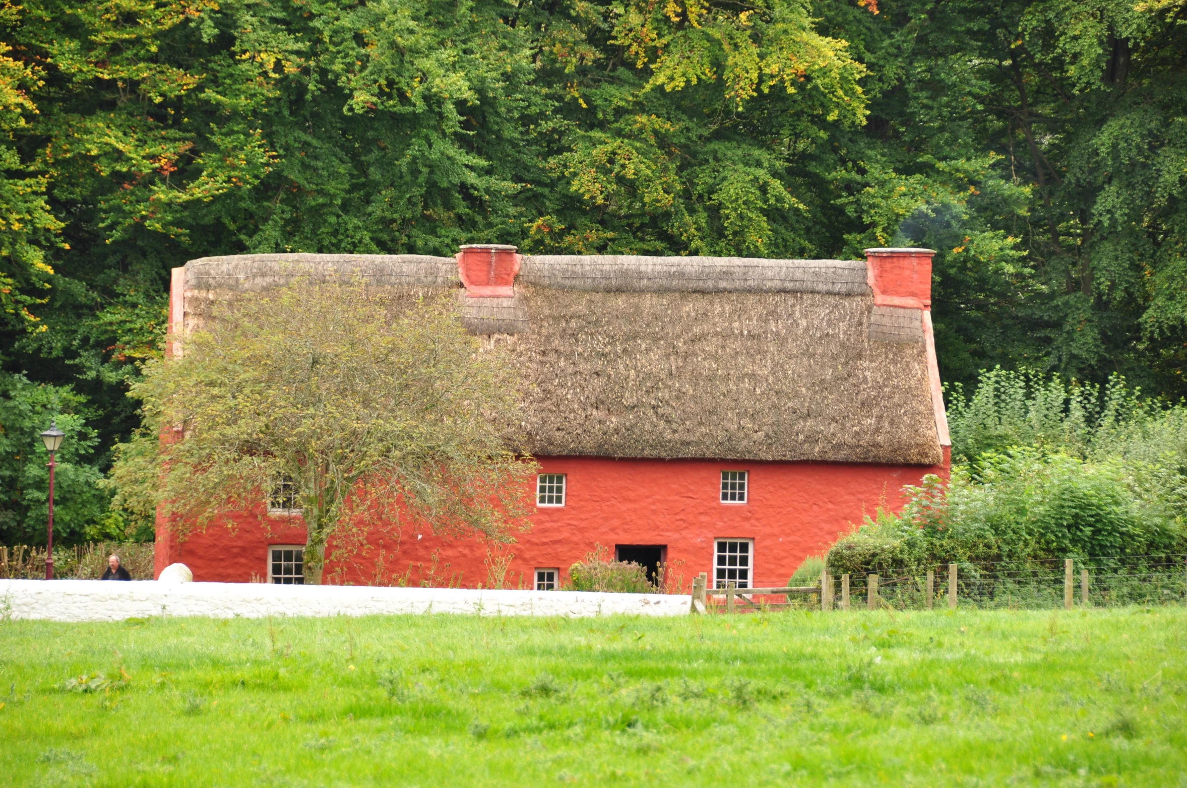 an old brick house with a thatched roof