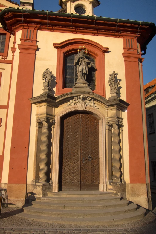 a red brick building with an elaborate doorway and a statue