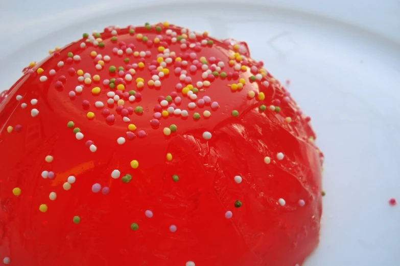 there is a red cake that is covered with sprinkles