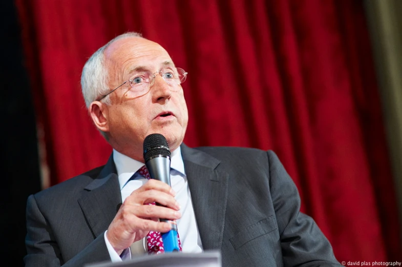 a man is giving a speech wearing glasses