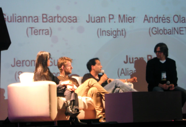 three men and two women sitting next to each other on stage