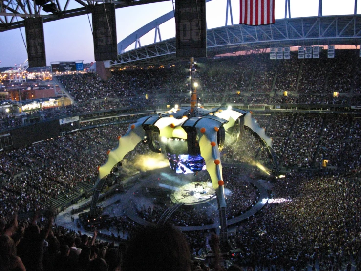 a huge crowd is in the stadium watching a concert