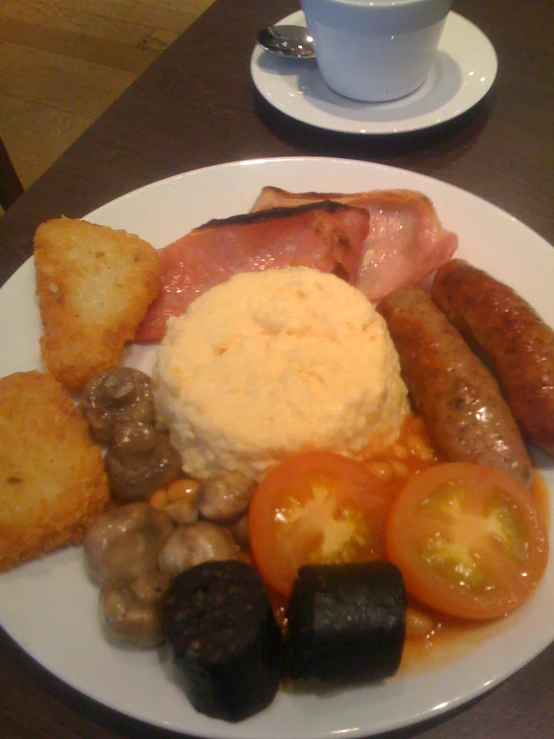 a plate filled with sausage and a lot of food on a table