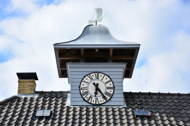 a clock tower with a sky background and clouds