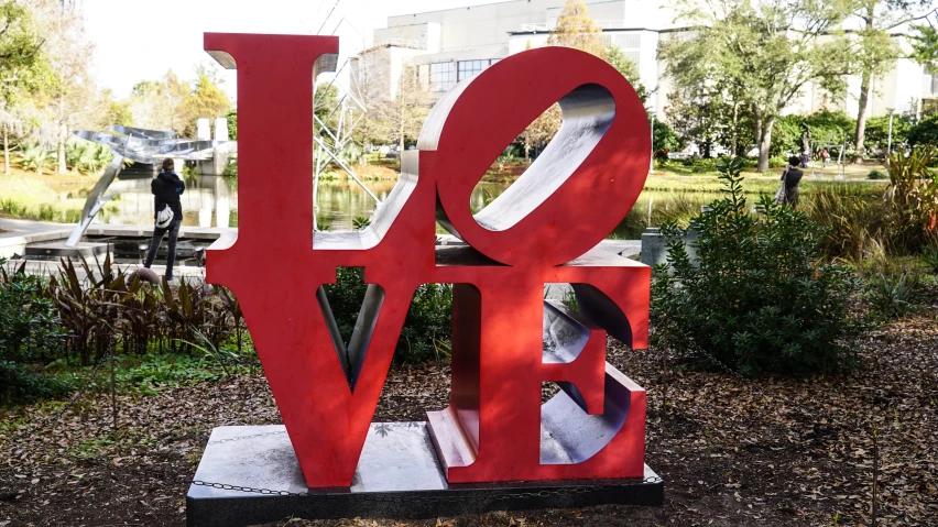 a red sculpture that has the words love spelled in the shape of the letters