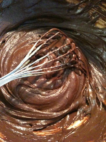 a bowl filled with chocolate and whisks in it