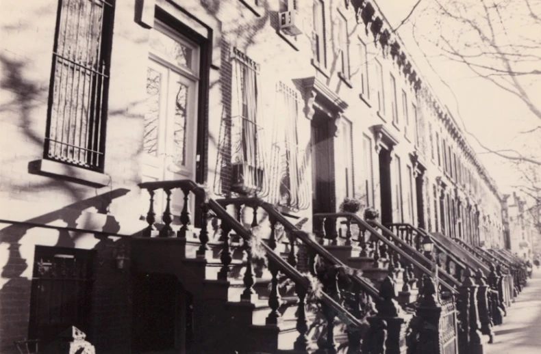 people standing outside a row of old houses