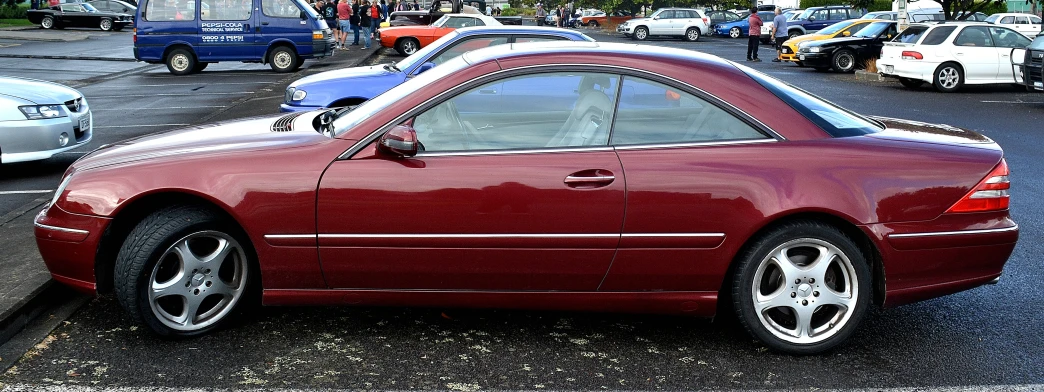 an automobile parked on the side of a road in a busy area