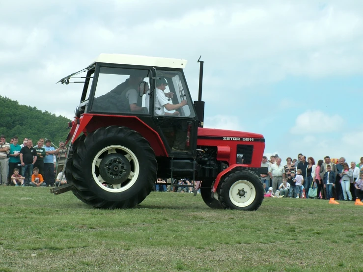 there is a large tractor that is riding on the grass