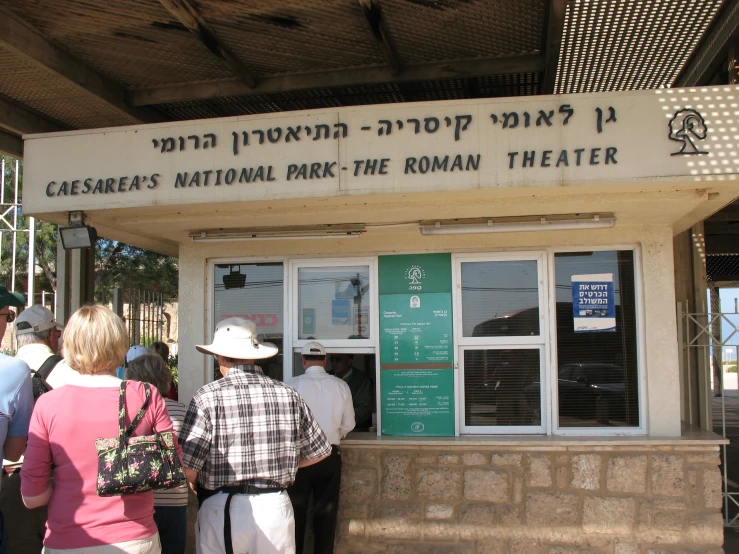 several people stand in line outside of a building