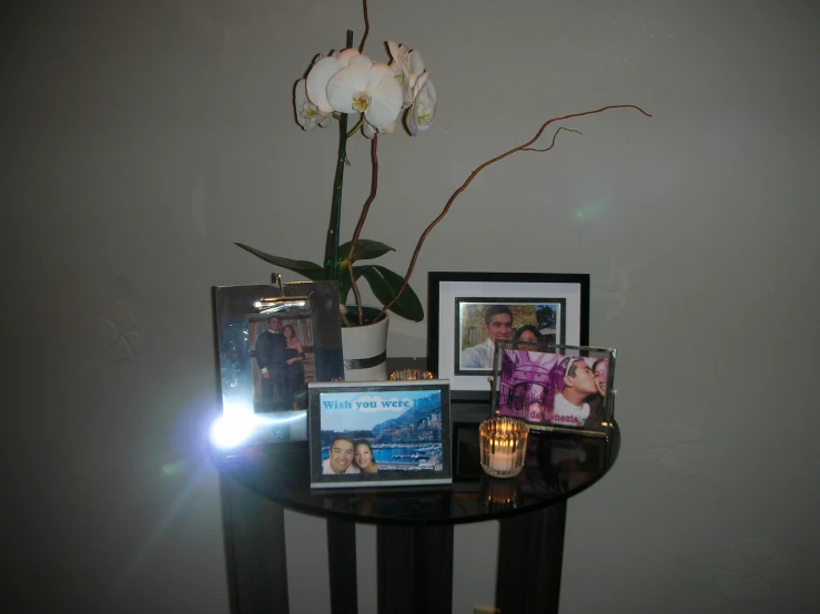 a glass table topped with pictures and flowers