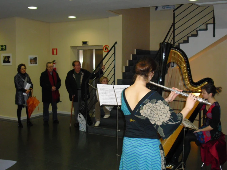 people with musical instruments standing in an otherwise open room