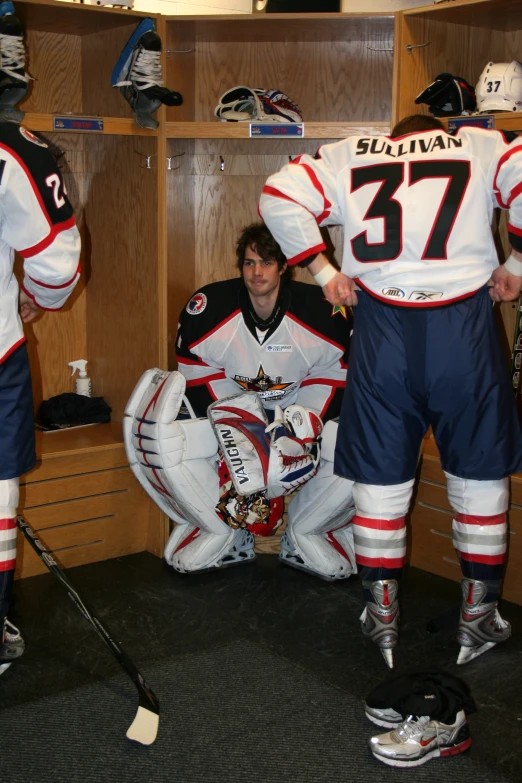 a hockey player is sitting in a locker