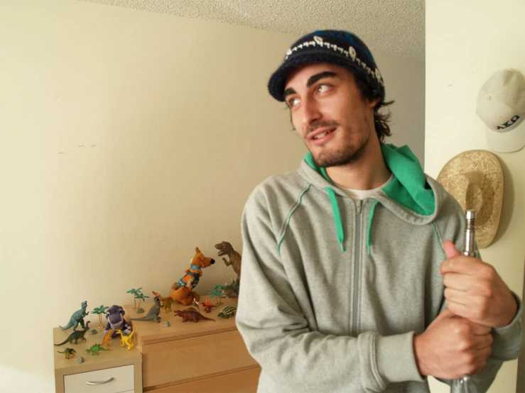 a man standing next to a wall with an odd looking hairbrush