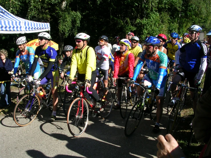 some people with bicycles standing around in the road