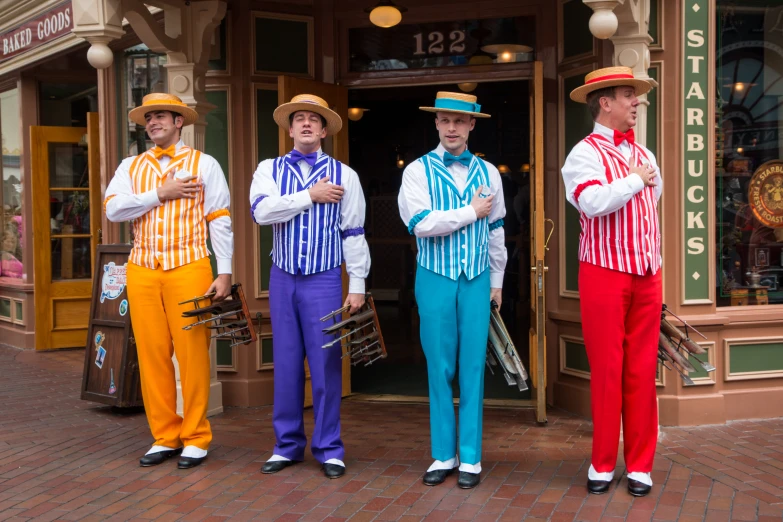 three men are dressed in colorful clothing, while holding their hands together