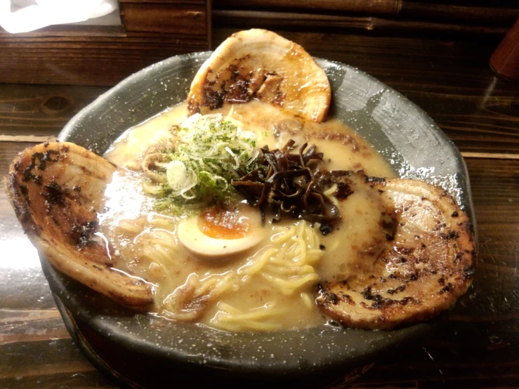 a plate topped with meat and pasta next to slices of orange