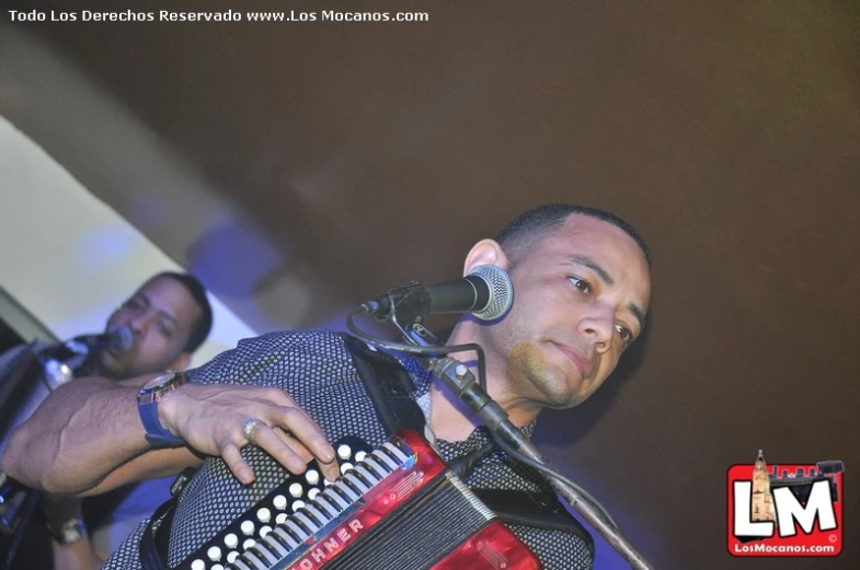 a man playing an accord and a microphone